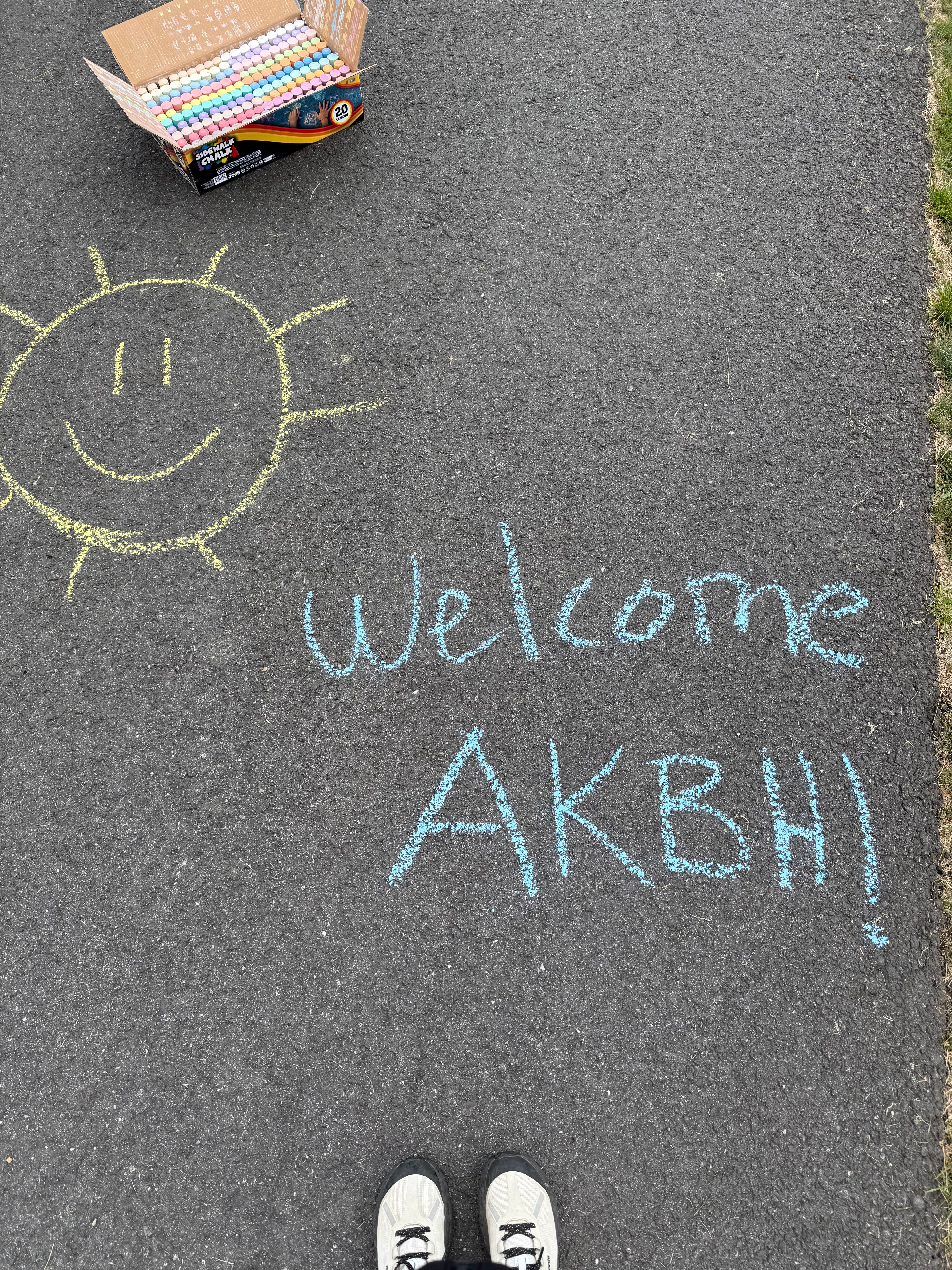 chalk writing on pavement: welcome AKBH